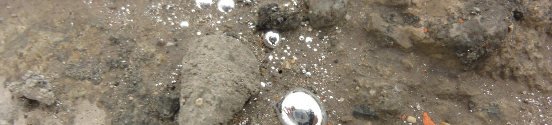 Gouttelettes de mercure libre sur une dalle de béton